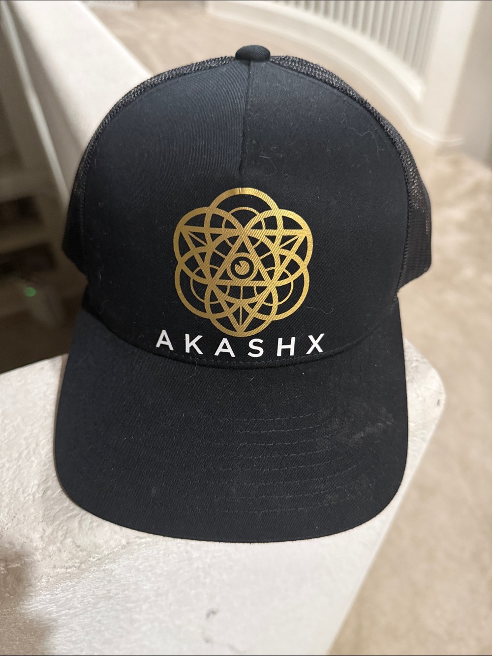 The Classic Black Trucker Hat with Gold Embroidered Logo